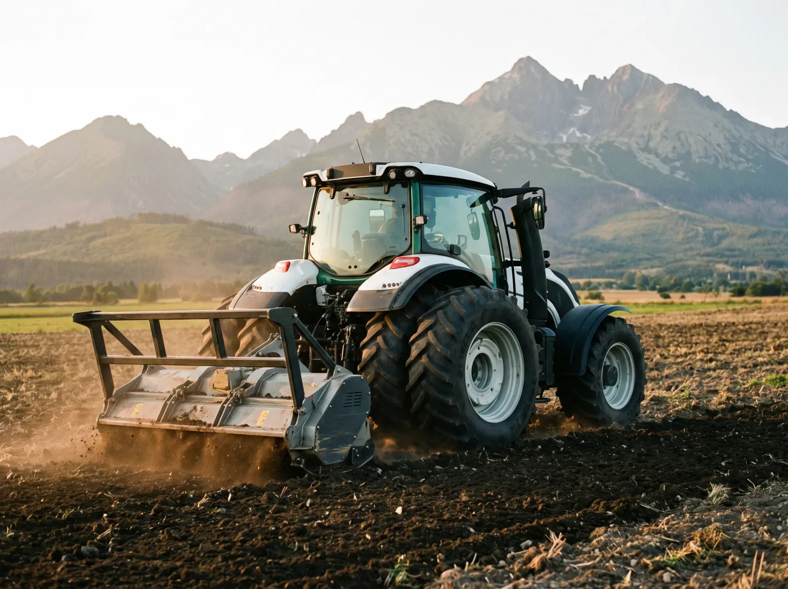 Traktor GEOMASTER s rotorovou frézou pri kultivovaní pôdy, za frézou rovnomerne rozhrabaná zem